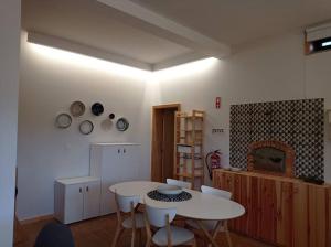 a kitchen with a table and chairs in a room at Casas do Penedo Lajão - Casa das Cerejas in Paredes de Coura