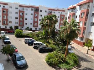 een parkeerplaats met auto's voor een gebouw bij apartment in Agadir 10 minutes from the beach in Agadir