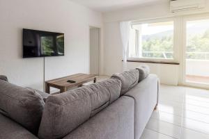a living room with a couch and a table at Immersi nella natura con accesso al fiume maggia in Locarno
