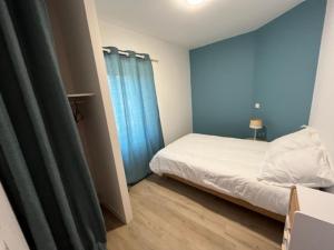 a small bedroom with a bed and a blue curtain at Les gîtes de Mazélise in Mazerolles