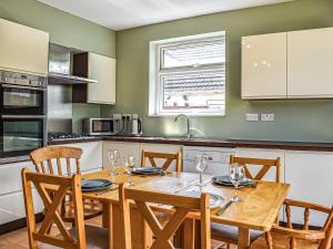 uma cozinha com uma mesa e cadeiras de madeira, uma mesa e uma espreguiçadeira em Number 12 em Poole