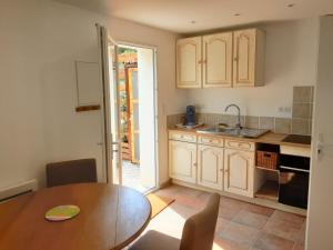 uma cozinha com uma mesa de madeira e uma sala de jantar em Le chemin de Bruniele em Aubres