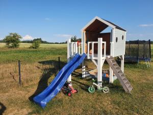 a playground with a slide and a play house at Mazurska Chatka Puchatka in Piecki