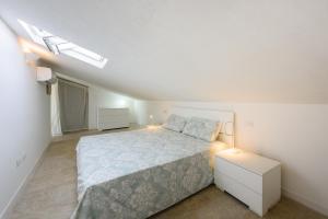 - une chambre blanche avec un lit et une table de nuit dans l'établissement Your Loft in Florence, à Florence