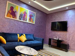 un salon avec un canapé bleu et une télévision dans l'établissement apartment in Agadir 10 minutes from the beach, à Agadir
