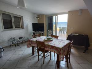 a dining room with a table and chairs and a view of the ocean at Casa Carmelo in Nizza di Sicilia