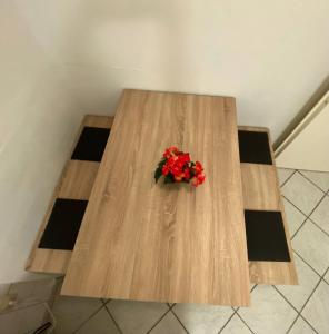 a wooden table with a bouquet of red flowers on it at Zentrales Apartment: Kreuzberg, Berlin in Berlin