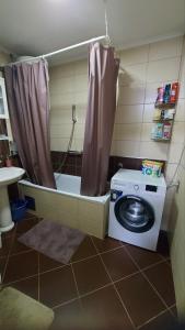 a washing machine in a bathroom with a shower at Apartman Gold in Tuzla