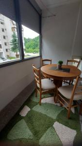 Habitación con mesa, sillas y ventana en Apartman Gold en Tuzla