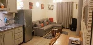 a kitchen and a living room with a couch and a table at Paradya Beach Apartments in Flic-en-Flac