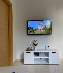 sala de estar con TV en una pared blanca en Seaside apartments, en Kaštela