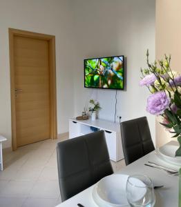 uma sala de estar com uma mesa e uma televisão na parede em Seaside apartments em Kaštela