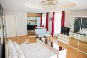 a living room with a white couch and a television at APARTHOTEL Panoramis Residence in Oradea