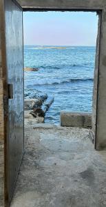 una porta aperta che guarda l'oceano di La Porta sul Mare a Siracusa
