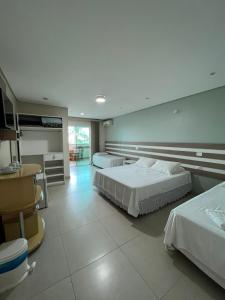 um quarto de hotel com duas camas e uma cozinha em Recanto Armação Pousada em Penha