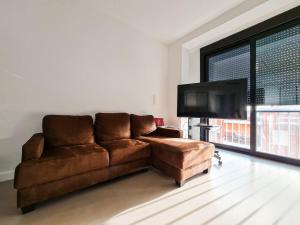 a brown leather couch in a living room with a flat screen tv at Lujoso apartamento junto a Museo Salzillo in Murcia