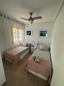 een slaapkamer met 2 bedden en een plafondventilator bij Vista Tabarca in Santa Pola