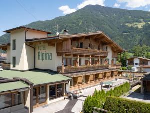 a building with a mountain in the background at Hotel Alpina in Ried im Zillertal
