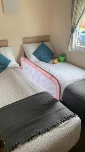 two beds in a small room withacers at Prime Location & Luxurious Hot Tub in Tattershall