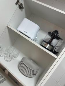 eine Küchentheke mit Tellern und Geschirr auf einem Regal in der Unterkunft Vista Tabarca in Santa Pola