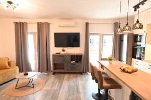 a kitchen and living room with a table and a television at Apartment Mina Dream in Jelsa
