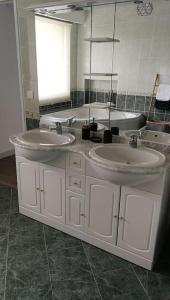 a bathroom with two sinks and a large mirror at Appartement calme et climatisé au cœur du village in Brazey-en-Plaine