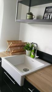 a white sink in a kitchen with a counter at Appartement calme et climatisé au cœur du village in Brazey-en-Plaine
