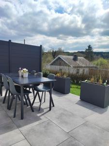 a table and chairs on a patio with plants at La maison des Oiseaux in Martelange