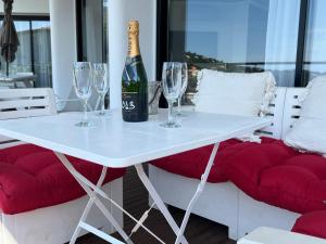 einen weißen Tisch mit Gläsern und eine Flasche Champagner in der Unterkunft GRANDE VILLA CALIFORNIENNE, 350 M2, VUE MER ET COLLINES, CAVALAIRE sur mer, 8 lits in Cavalaire-sur-Mer