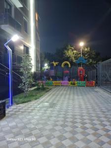 um parque infantil em frente a um edifício à noite em Квартира в новом жилом комплексе Mega Tower em Tashkent