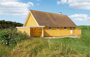 une maison jaune avec un toit brun dans un champ dans l'établissement Amazing Home In Harbore With 2 Bedrooms, Sauna And Wifi, à Harboør