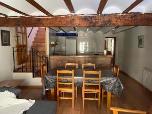 una sala da pranzo con tavolo e 4 sedie di Casa Rural Aras Apartamentos Turísticos ad Aras de Olmos