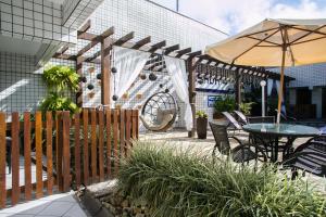 patio con tavolo e ombrellone di Hotel Pousada Porto da Lua a Guaratuba