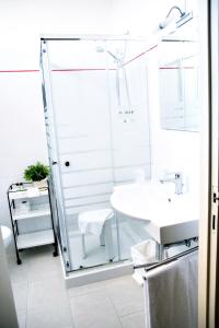 a bathroom with a glass shower and a sink at Hotel Kinda in Castiglione della Pescaia