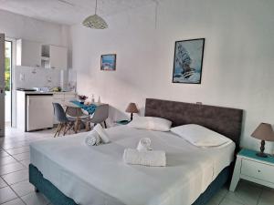 ein Schlafzimmer mit einem großen weißen Bett und eine Küche in der Unterkunft Βig Βlue Apartments in Makry Gialos
