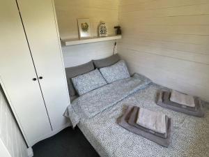 Habitación pequeña con 1 cama y 2 almohadas en Piejūras Kaķīšu namiņš en Ķesterciems