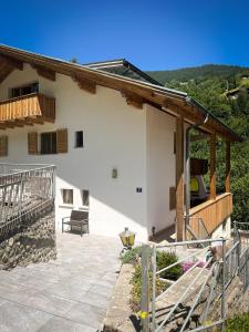 a house with a balcony and a patio at Spitzen Blicke – Apartments in Silbertal
