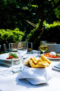 a table with a plate of food and glasses of wine at Hotel Forum in Pompei