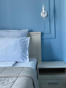 a blue bedroom with a bed and a nightstand with a blue wall at Mini Hotel 7 Street in Sukhum