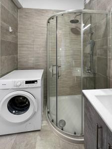 uma máquina de lavar roupa na casa de banho com um chuveiro em Ameli Apartment , Spacious With Mountain View, Lefkada em Dhráganon