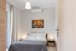 um quarto com uma cama e um quadro na parede em Ameli Apartment , Spacious With Mountain View, Lefkada em Dhráganon
