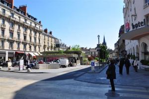 a person walking down a city street with buildings at Le Darcy, grand appartement centre ville Dijon, proche gare in Dijon +1 photo
