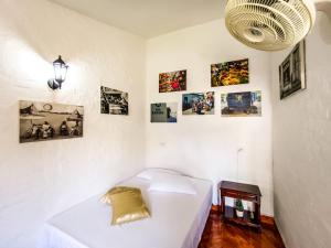 um quarto com um sofá branco e fotografias na parede em Melao Hostel Campestre y Vivero em Palmira