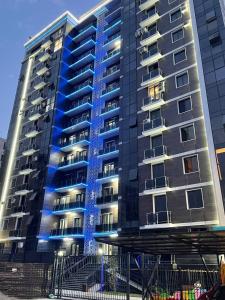 um edifício com luzes azuis na lateral em Квартира в новом жилом комплексе Mega Tower em Tashkent