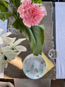 a vase with a pink flower in it on a table at Mini Hotel 7 Street in Sukhum