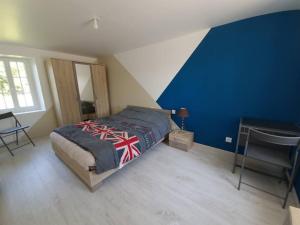 ein Schlafzimmer mit einem Bett und einer blauen Wand in der Unterkunft Logement indépendant et aménagé au calme in Bouzy-la-Forêt