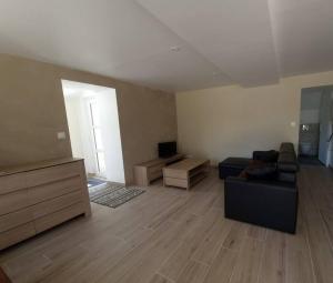 ein Wohnzimmer mit einem Sofa und einem Tisch in der Unterkunft Logement indépendant et aménagé au calme in Bouzy-la-Forêt