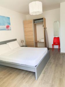 1 dormitorio con 1 cama y 1 silla roja en Conero-30 mt dal Mare, Corte e Spiaggia di sabbia-Stella en Porto Potenza Picena