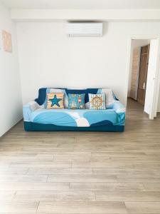 un sofá azul sentado en una sala de estar en Conero-30 mt dal Mare, Corte e Spiaggia di sabbia-Stella en Porto Potenza Picena