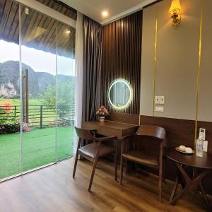 a dining room with a table and chairs and a large window at Amazing View Homestay in Ninh Binh